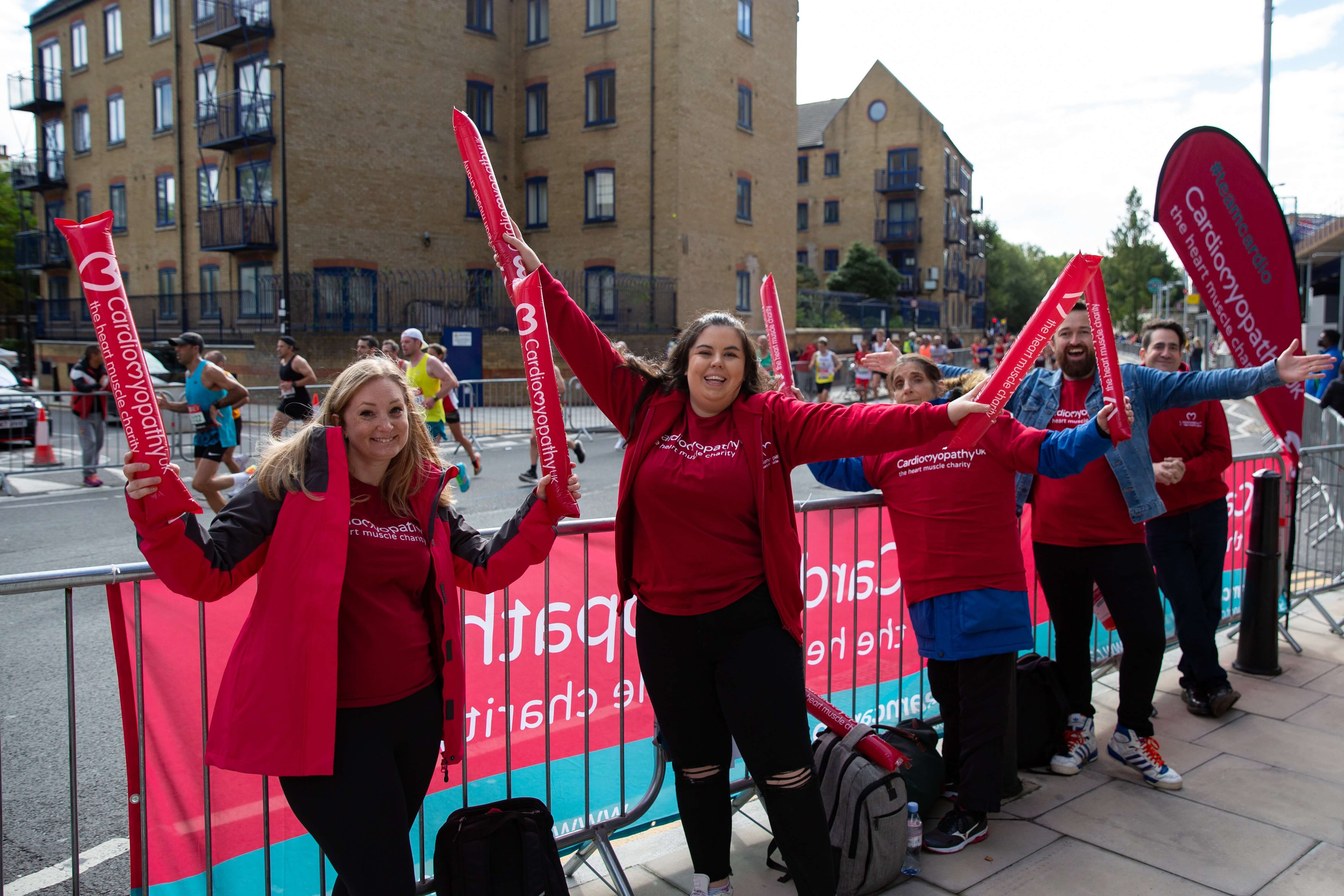 Group of Cardiomyopathy UK volunteers waving cheer sticks at the London Marathon