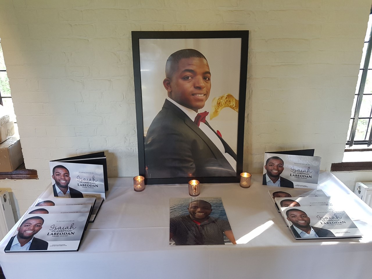 Tribute table for Zai with photos, candles and leaflets