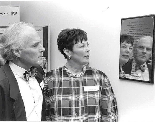 Two people looking at a plaque on the wall