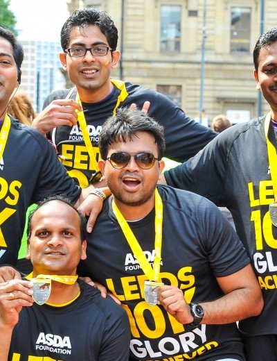 Group of runners posing for photo with their medals